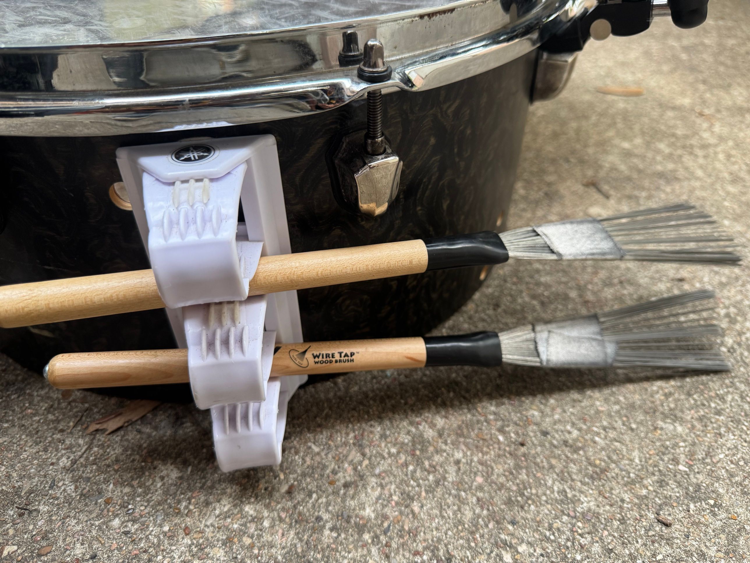 Two Vater Wire Tap wood brushes held in a white Yamaha clip holder on the floor-tom shell.