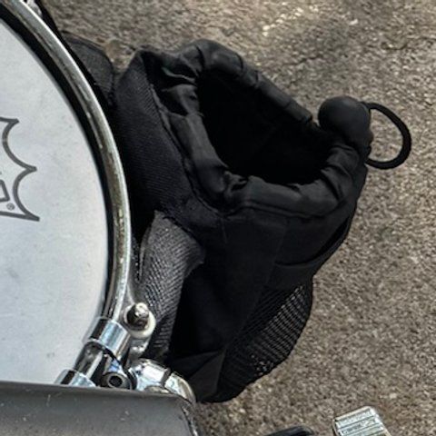 A black padded bike cup holder attached next to the snare.