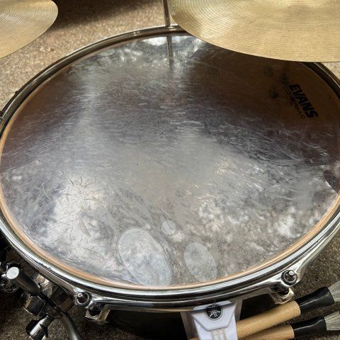 A 14-inch floor tom seen from above, with a clear Evans Hydraulic head and a chrome hoop.